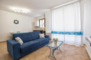 salon z niebieską kanapą i stołem w obiekcie La Casa di Noemi w mieście Alghero