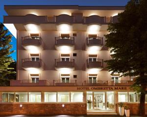 a hotel on the corner of a building with lights at Hotel Ombretta Mare in Rimini