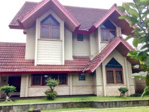 una casa con techo rojo en Villa Nuansa Alam en Lembang