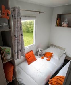 a small bedroom with a bed with a window at camping Le Médiéval in Turckheim
