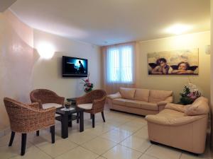 a living room with a couch and a table and chairs at Hotel Ombretta Mare in Rimini