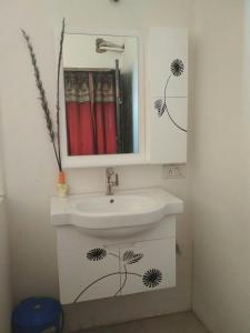 a bathroom with a sink and a mirror at Ashta Lakshmi Tourist Home Stay in Indore