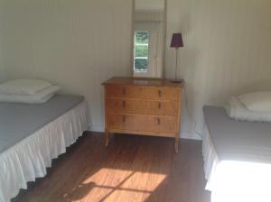 a bedroom with two beds and a dresser and a window at Villa Lavendel in Borgholm