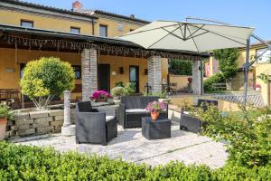 a patio with chairs and an umbrella in a yard at Cerasus B&B in San Marcello