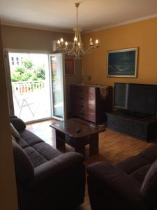 a living room with a couch and a tv and a table at jakov in Podgora