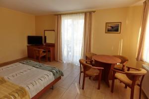 a bedroom with a bed and a table and chairs at Holiday-Darłówko in Darlowko