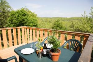 a blue table on a deck with a view at Camping les Chênes in Chauzon