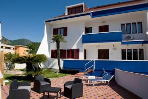 a white and blue house with chairs and a table at Villitaly suite & coffee Salerno in Baronissi