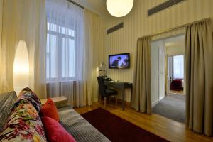 a living room with a couch and a desk at Best Western Premier Hotel Victoria in Freiburg im Breisgau