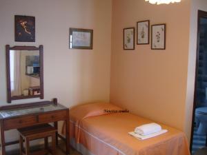 Zimmer mit 2 Betten, einem Spiegel und einem Tisch in der Unterkunft Studio Nausica... a sense of paradise! in Agia Pelagia Chlomou