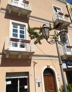 a building with two balconies and a street light at L'alberghetto Milazzo in Milazzo