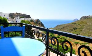 a blue chair sitting on a balcony with a view of the ocean at Margarita Hotel in Kythira