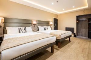 duas camas num quarto de hotel com duas camas em Arosfa Hotel London by Compass Hospitality em Londres