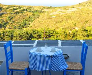 a table with a blue and white checkered table cloth and two chairs at Margarita Hotel in Kythira