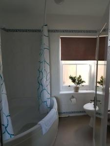a bathroom with a tub and a toilet and a window at Waterfront Hotel in Deal