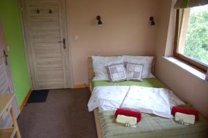 a small bedroom with a bed with two pillows on it at Pokoje Gościnne Pod Ciupagą in Bukowina Tatrzańska