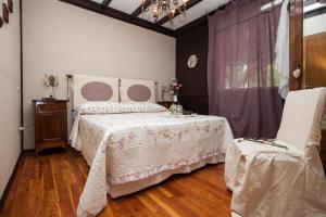 - une chambre avec un lit et deux chaises dans l'établissement Cugi Bed and Breakfast, à San Damiano dʼAsti