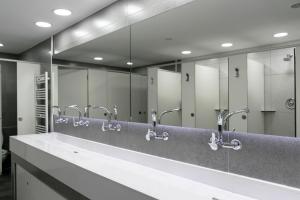 a bathroom with a row of sinks and mirrors at Alberguinn in Barcelona