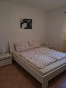 1 cama en un dormitorio con una foto en la pared en Apartment Tanja, en Vrsar