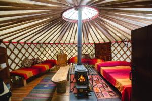 a yurt with red beds and a fireplace in it at Larkhill Tipis and Yurts in Carmarthen