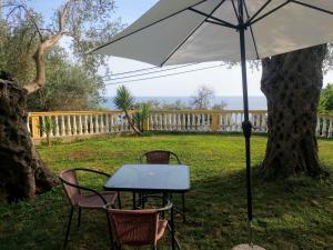 a table and chairs with an umbrella in a yard at Apartment Spuza in Ulcinj