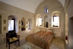 a bedroom with a bed and a chair and windows at Kasr-i Nehroz Hotel in Midyat +57 photos