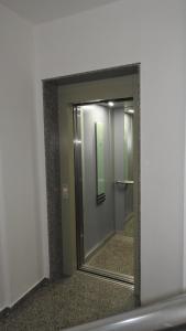 a mirror in a bathroom with a reflection of a door at Apartments Vila Cala in Durrës