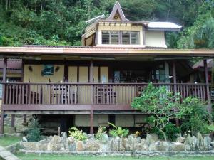een huis met een groot terras met een veranda bij Coconut Garden Island Resort in San Vicente