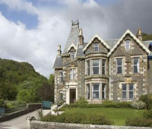 una vecchia casa in pietra con una torre di Kilchrenan House a Oban