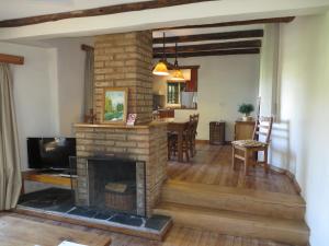 a living room with a fireplace and a dining room at Acacias Country Club in Sierra de la Ventana