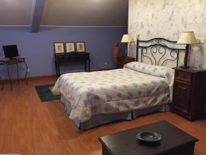 a bedroom with a bed, chair, desk and a lamp at Hotel Benlloch in Salas de los Infantes