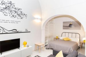 Schlafzimmer mit einem Bett und einem TV in der Unterkunft Terè in Noci
