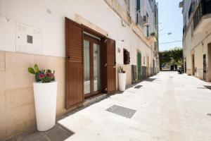 eine leere Gasse mit Pflanzen in Töpfen auf einem Gebäude in der Unterkunft Terè in Noci