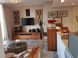 sala de estar con TV y sofá en Harbour Bridge Suite 220, en Ciudad del Cabo