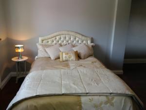 a bedroom with a bed with a white bedspread and pillows at Higherlands in Kingsley