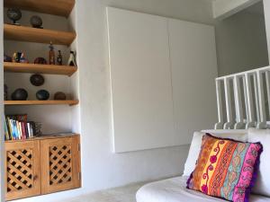 a room with a couch and a book shelf at Villa Maria Bed and Breakfast in Puerto Escondido