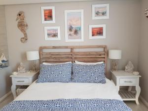 Un dormitorio con una cama con almohadas azules y blancas. en Harbour Bridge Suite 220, en Ciudad del Cabo 50 fotos más