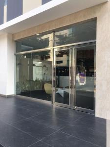 un edificio con puertas de cristal con reflejo de un autobús en Eduardo Designer Apartments Miraflores en Lima