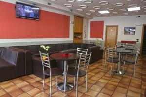 a waiting room with tables and a couch at Albergo Gusmeroli in Tirano