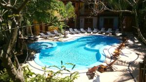 a swimming pool with lounge chairs in a resort at Hotel El Pueblito in Holbox Island