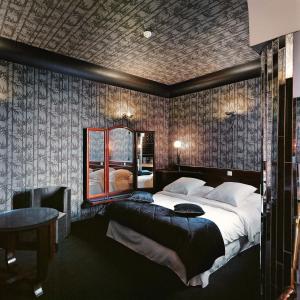 a hotel room with a bed and a night stand at Le Berger Hotel in Brussels