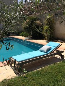 a blue chaise lounge next to a swimming pool at La Forge in Gignac