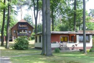 uma pequena casa no meio de uma floresta em Ferienhaus direkt am See em Bad Saarow