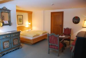 湖畔捷爾的住宿－埃爾霍夫餐廳酒店，卧室配有一张床和一张桌子及椅子