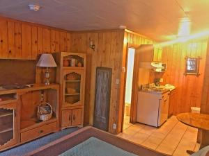 a kitchen with wooden walls and a refrigerator and a table at Caboose Motel & Gift Shop in Durango