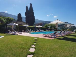 a swimming pool with lounge chairs and umbrellas at Podere Piana in Reggello