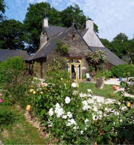 uma casa de pedra com flores em frente em Chambre d'hôtes Saint Jacob Relais de Chasse du XVIII Siècle em Les Fougerêts