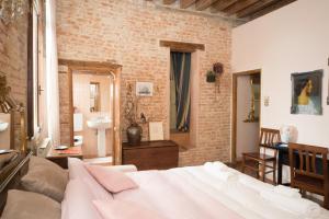 a bedroom with a bed and a brick wall at San Polo Home in Venice