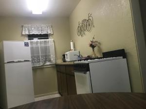 a small kitchen with a stove and a refrigerator at Caboose Motel & Gift Shop in Durango