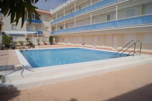 a swimming pool in front of a building at Apartamentos San Miguel in Alcossebre